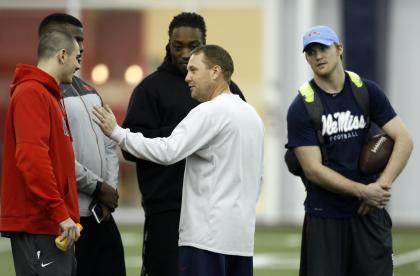 Mississippi football coach Hugh Freeze, second from right, speaks with players quarterback Chad Kelly, left, defensive ends Channing Ward, second from left, Fadol Brown, center, as former Mississippi quarterback Bo Wallace listens in during Pro Day at Mississippi in Oxford, Miss., Thursday, March 5, 2015. The event showcases players for the upcoming NFL football draft. (AP Photo/Rogelio V. Solis)