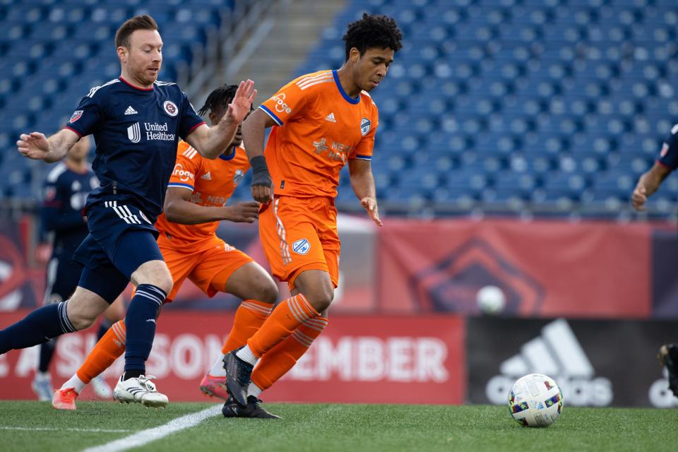 Quimi Ordonez (center) dribbles away from the New England Revolution's Tommy McNamara.