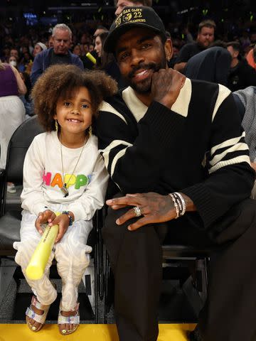 <p>Jim Poorten/NBAE via Getty</p> Kyrie Irving and his daughter Azurie during Game 6 of the 2023 NBA Playoffs.