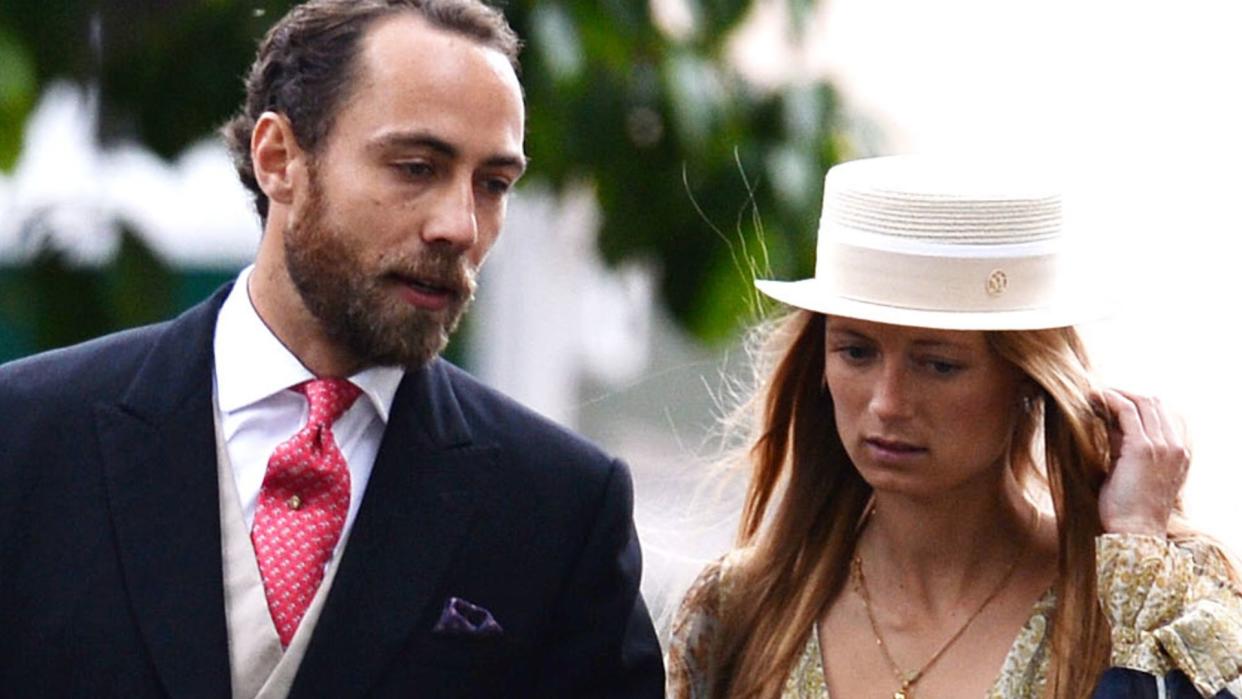 Alizee Thevenet holding her white hat with her arm through James Middleton's