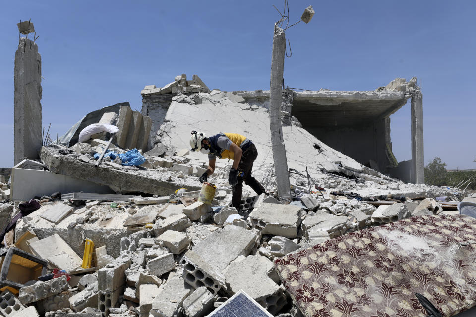 A civil defense worker inspects a damage house after shelling hit the town of Ibleen, a village in southern Idlib province, Syria, Saturday, July 3, 2021. Artillery fire from government-controlled territory Saturday killed at least eight civilians in Syria's last rebel enclave, most of them children, rescue workers and a war monitor said. (AP Photo/Ghaith Alsayed)