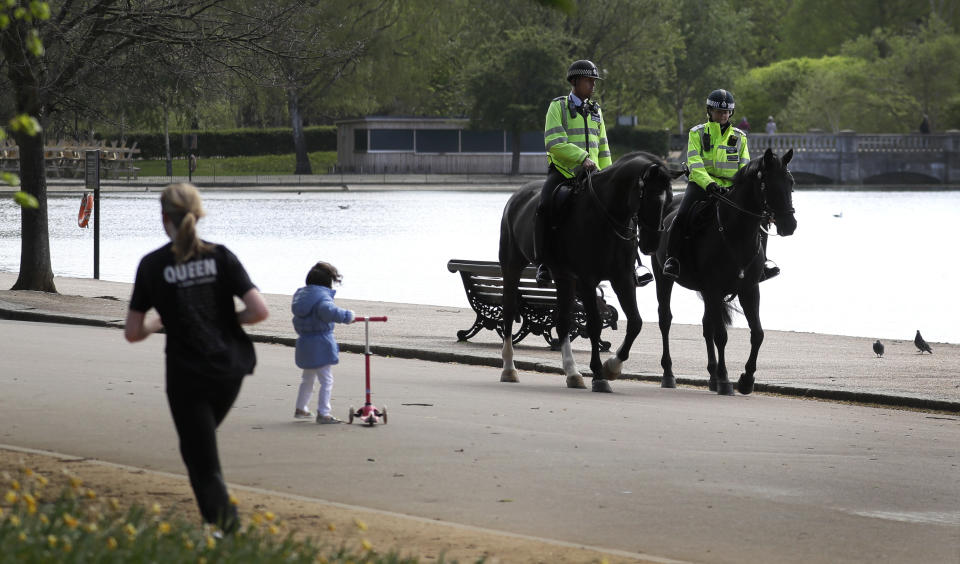 Mounted police officers patrol in Hyde Park, as the country is in lockdown to help curb the spread of the coronavirus, in London, Monday, April 13, 2020. The new coronavirus causes mild or moderate symptoms for most people, but for some, especially older adults and people with existing health problems, it can cause more severe illness or death. (AP Photo/Kirsty Wigglesworth)