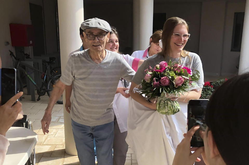 In this photo provided by the Vilanova nursing home, resident Mr Chatal smiles during a fake wedding with a nurse on April 25 2020 in Corbas, central France. The nursing staff of a care home in Lyon decided 45 days ago that rather than lock residents in their rooms as the government urged, the staff would lock themselves in the home with residents so as not to deprive the elderly of their freedom. The home has had zero virus cases so far. (Valerie Martin via AP)