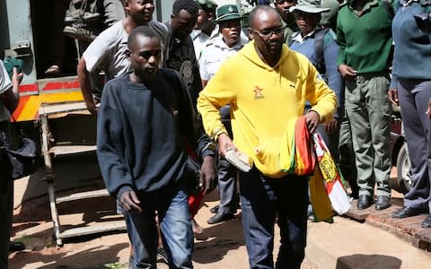 Pastor and activist Evan Mawarire right, arrives at the magistrates courts in Harare,  - Credit: &nbsp;Tsvangirayi Mukwazhi/&nbsp;AP