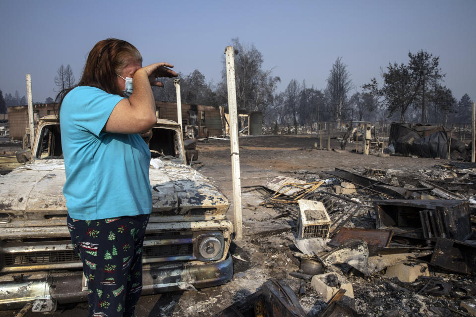 Heather Marshall stands amid what remains of her home at Coleman Creek Estates mobile home park in Phoenix, Oregon, on Thursday. The area was destroyed when a wildfire swept through on Tuesday. The Marshalls had lived at the park for 21 years. (Photo: Paula Bronstein/ASSOCIATED PRESS)