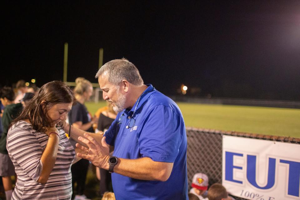 Fellowship of Christian Athletes area director Kirk Shepard prays with Amy Whitaker during a gathering at Spring Hill High School in Spring Hill, Tenn., on Wednesday, Oct. 13, 2021.