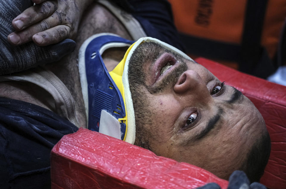 Rescuers pulled out a man from a collapsed building 87 hours after the earthquake in Kahramanmaras, southern Turkey, Thursday, Feb. 9, 2023. Thousands who lost their homes in a catastrophic earthquake huddled around campfires and clamored for food and water in the bitter cold, three days after the temblor and series of aftershocks hit Turkey and Syria. ( IHA via AP)