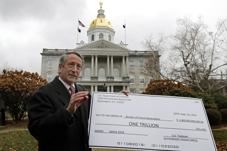 Republican presidential candidate former South Carolina Gov. Mark Sanford holds a large check representing the national debt as he holds a news conference in front of the Statehouse, Tuesday, Nov. 12, 2019, in Concord, N.H. Sanford announced he is ending his longshot 2020 presidential bid. Sanford centered his Republican primary challenge to President Donald Trump on warnings about the national debt. But he struggled to gain traction since announcing his run in September. (AP Photo/Elise Amendola)
