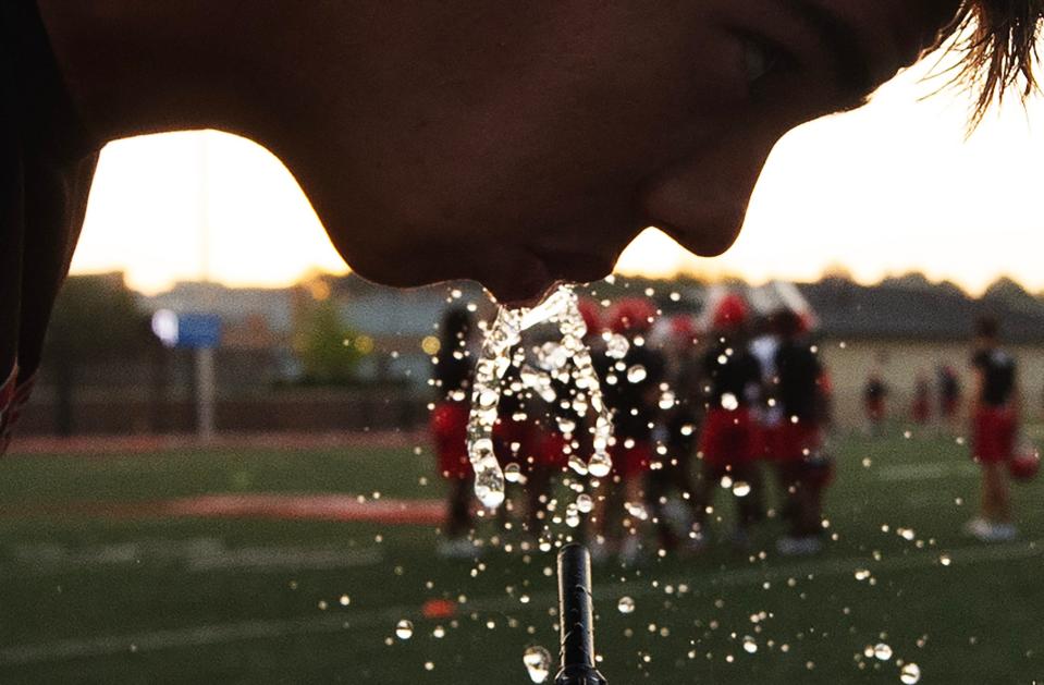 A Brandon football player pauses to hydrate during an early-morning practice in Brandon on Monday, July 31. Although the practice began before sunrise, the heat and humidity of the day were already rising.