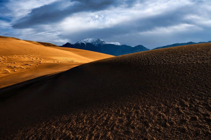 Snow capped mountain and dunes, Great Sand Dunes National Park.