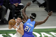 Phoenix Suns Devin Booker, left, is fouled as he drives to the basket against Milwaukee Bucks' Jrue Holiday, right, during the second half of an NBA basketball game Monday, April 19, 2021, in Milwaukee. (AP Photo/Aaron Gash)