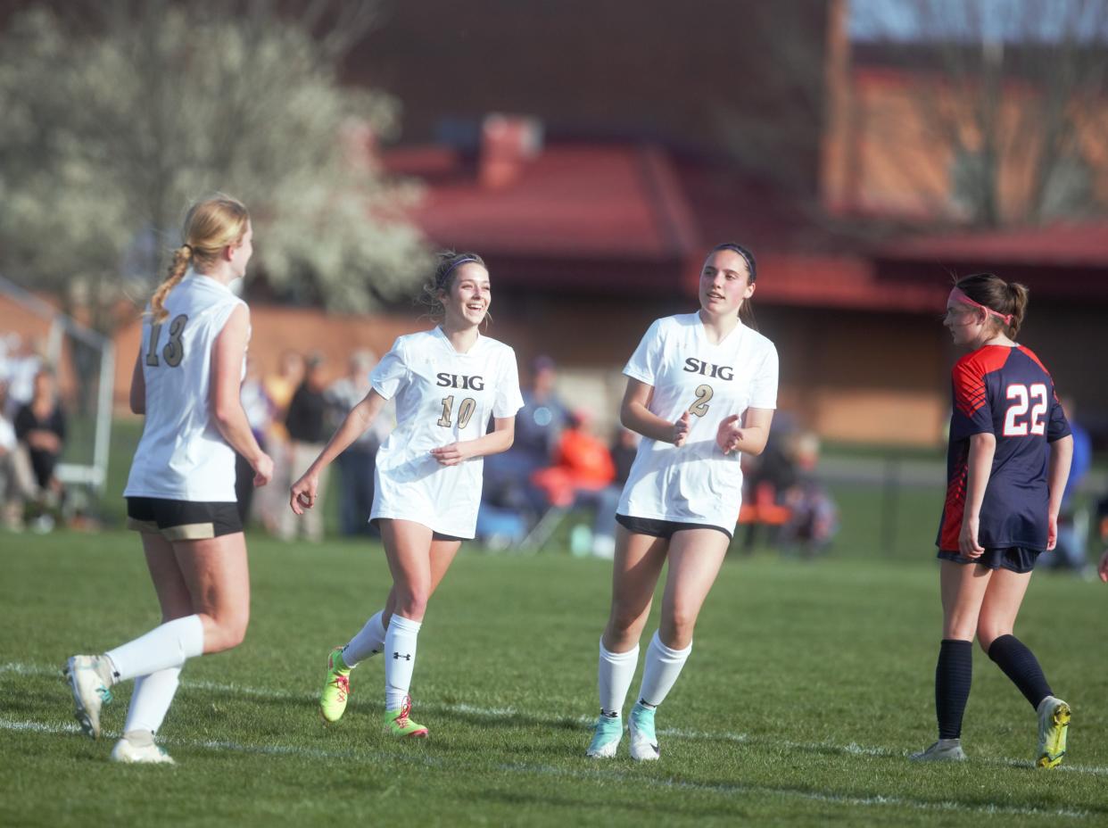 Sacred Heart-Griffin's Isabella Perryman (10) and Lauren Johannes (2) react after Caroline Sheehan scored on a penalty kick against Rochester during a Central State Eight Conference girls soccer match on Tuesday, April 9, 2024. SHG won 2-0.
