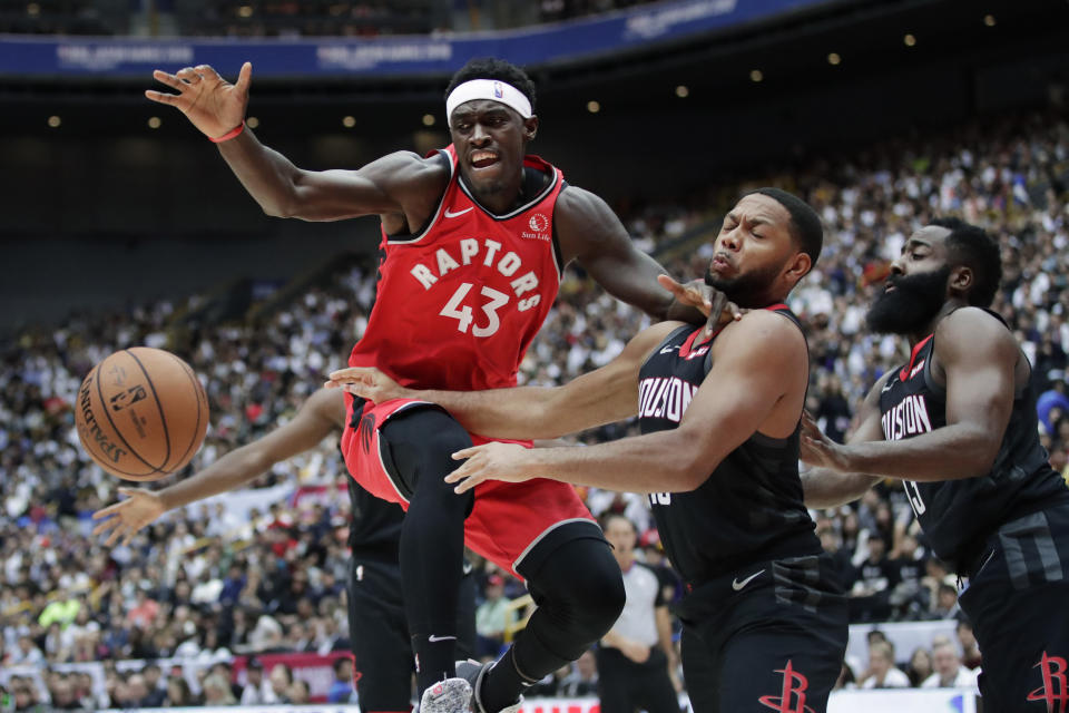 Toronto Raptors' Pascal Siakam, left, fights for a loose ball with Houston Rockets' Eric Gordon during the first half of an NBA preseason basketball game Thursday, Oct. 10, 2019, in Saitama, near Tokyo. (AP Photo/Jae C. Hong)