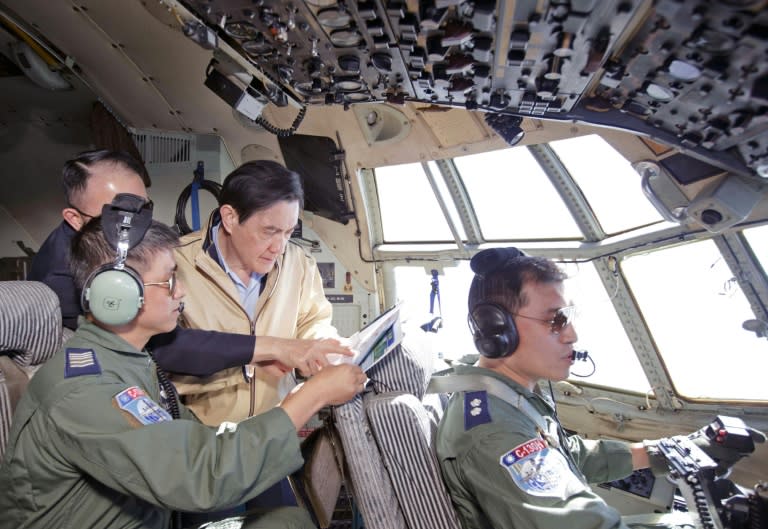 Taiwan President Ma Ing-jeou (2nd R) being shown a map during his flight on board a military C-130 transport aircraft to Taiping island