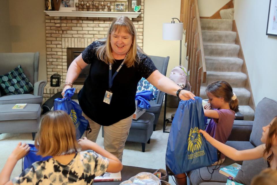 Judy Hengstebeck, Gahanna-Jefferson Public Schools' communications coordinator, hands out book gift packages sent from the Chautauqua Short Story Discussion Group to High Point Elementary School students during their own book club meeting June 23 in Gahanna.