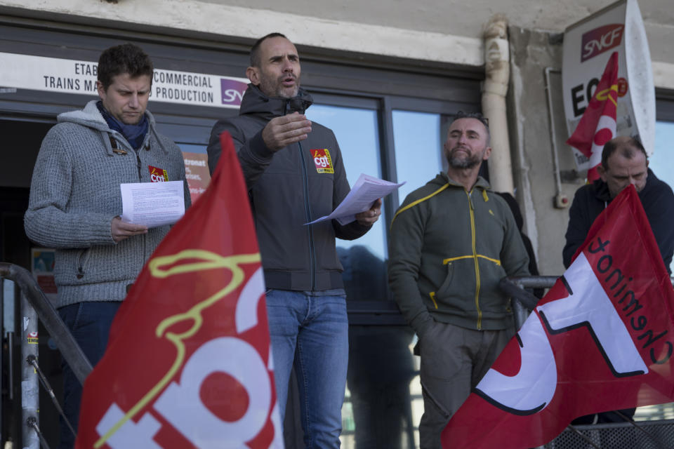 A striking railway worker speaks during a union general assembly meeting at the Gare St-Charles station in Marseille, southern France, Monday, Dec. 9, 2019. Paris commuters inched to work Monday through exceptional traffic jams, as strikes to preserve retirement rights halted trains and subways for a fifth straight day. (AP Photo/Daniel Cole)