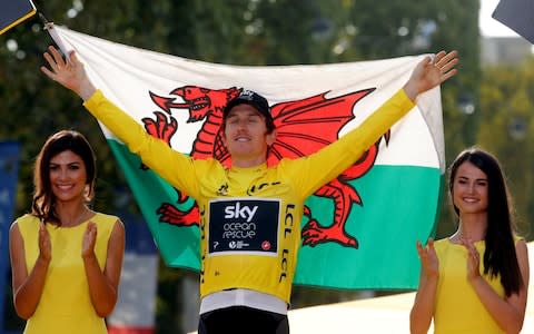 Team Sky rider Geraint Thomas of Britain celebrates his overall victory on the podium with a Welsh flag - Credit:  REUTERS