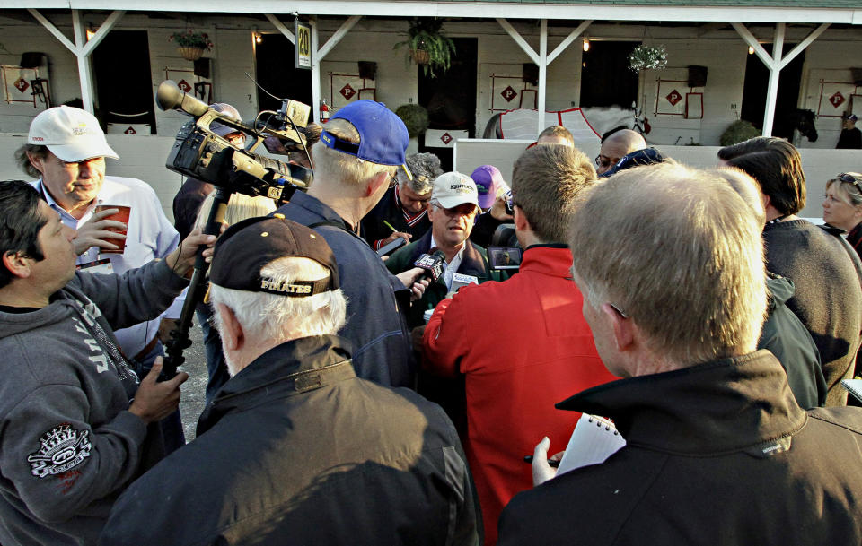 Trainer Art Sherman, center, speaks to the media about Kentucky Derby 140 winner California Chrome, outside Barn 20 at Churchill Downs in Louisville, Ky., Sunday, May 4, 2014. (AP Photo/Garry Jones)