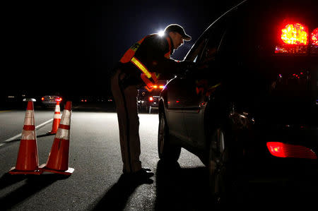 FILE PHOTO: A Jefferson County Sheriff Deputy asks a driver if he has been drinking while smelling for alcohol at a mobile Driving Under the Influence (DUI) checkpoint in Golden, Colorado, U.S. on April 12, 2008. REUTERS/Rick Wilking/File Photo