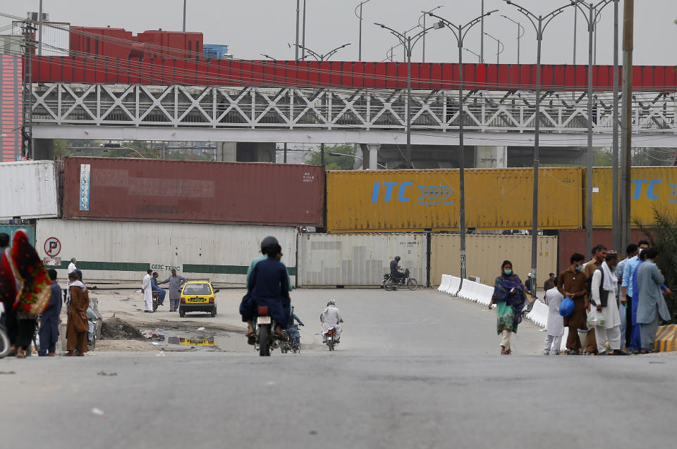 Shipping containers are placed by authorities to block a road leading to the capital as a security measure on the possible anti-France protest march by a banned radical Islamists Tehreek-e-Labaik Pakistan party, in Rawalpindi, Pakistan, Tuesday, April 20, 2021. Pakistan's Parliament is expected to consider a resolution on Tuesday about whether the French envoy should be expelled over the publication of controversial cartoons depicting Islam's Prophet, testing whether the government gives in to threats from radical Islamists. (AP Photo/Anjum Naveed)