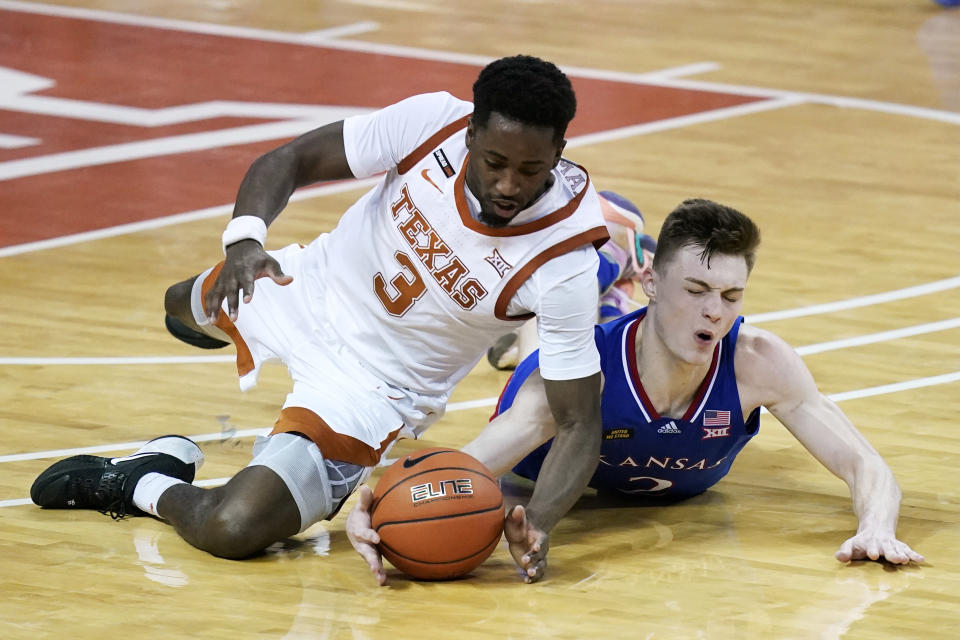 Texas guard Courtney Ramey (3) fights for a loose ball with Kansas guard Christian Braun during overtime in an NCAA college basketball game, Tuesday, Feb. 23, 2021, in Austin, Texas. (AP Photo/Eric Gay)