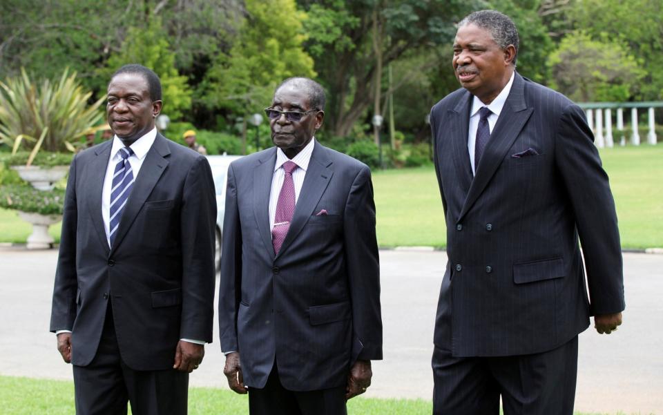 Then-Zimbabwe President Robert Mugabe is seen with vice presidents Phelekezela Mphoko (R) and Emmerson Mnangagwa (L) at State House in Harare - REUTERS