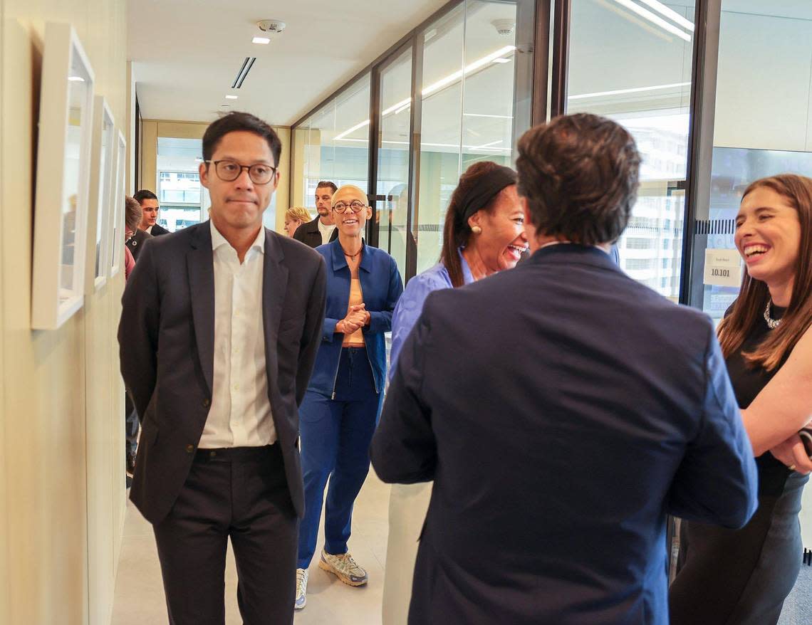 Artist Najja Moon, center, chats with visitors as they tour the new European bank BNP Paribas office after its opening Wednesday, December 6, 2023 at the Brickell financial district in Miami, Florida.