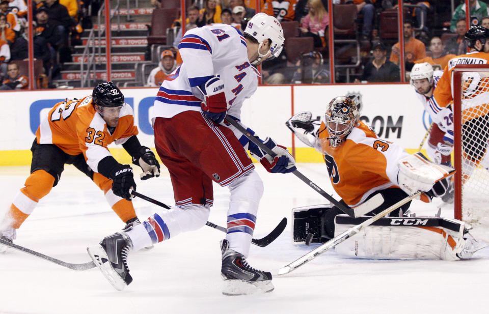 Philadelphia Flyers' Steve Mason, front right, looks to stop the shot by New York Rangers' Rick Nash, center, with Flyers' Mark Streit, left, of Switzerland, reaching for the puck with his stick during the second period in Game 4 of an NHL hockey first-round playoff series on Friday, April 25, 2014, in Philadelphia. (AP Photo/Chris Szagola)