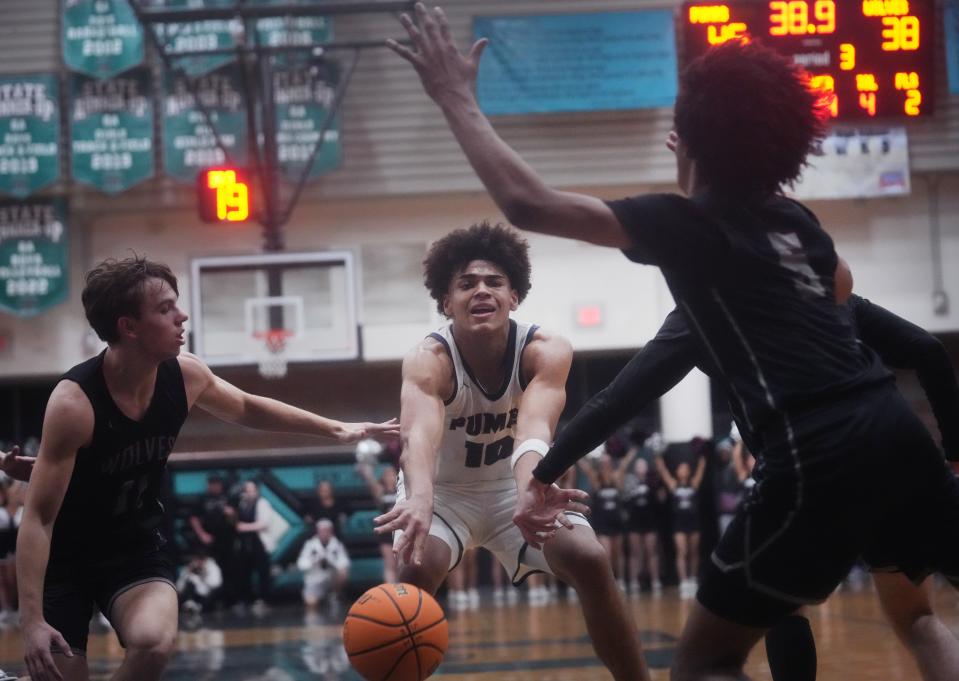 Perry Pumas forward Koa Peat (10) passes the ball into the defense of the Desert Mountain Wolves at Highland High School gym in Gilbert on Feb. 24, 2023.