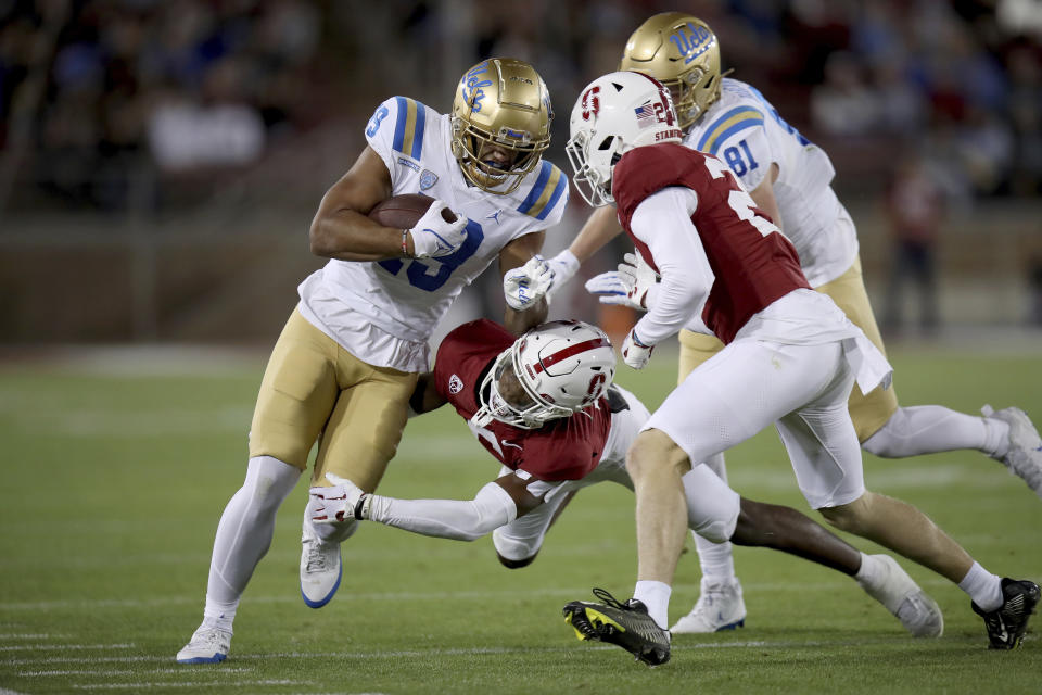 UCLA wide receiver Kyle Ford (19) is brought down by Stanford cornerback Collin Wright, bottom, during an NCAA college football game, Saturday, Oct. 21, 2023, in Stanford, Calif. (AP Photo/Scot Tucker)