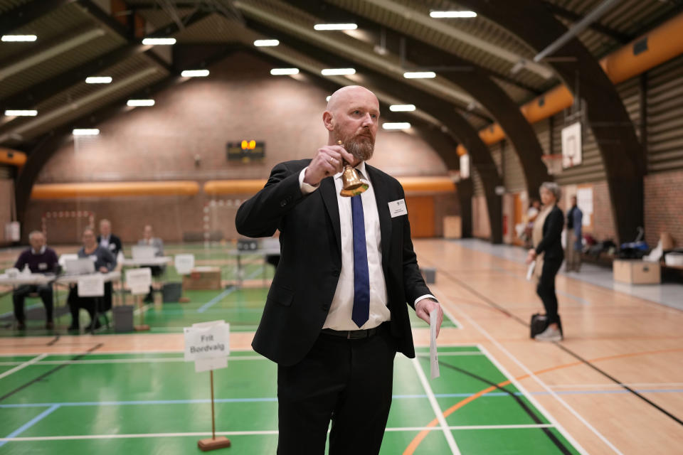 Election Commission official rings a bell to mark voting open at a polling station in Hareskovhallen in Vaerloese, Denmark, on Tuesday, Nov 1, 2022. Denmark's election on Tuesday is expected to change its political landscape, with new parties hoping to enter parliament and others seeing their support dwindle. A former prime minister who left his party to create a new one this year could end up as a kingmaker, with his votes being needed to form a new government. (AP Photo/Sergei Grits)