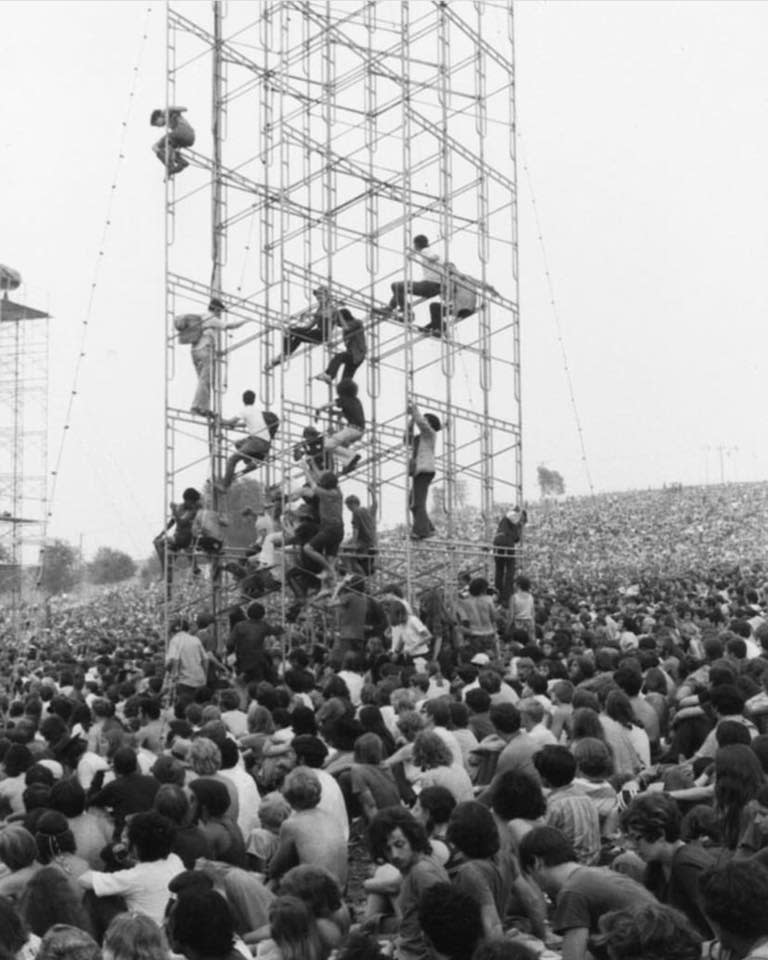 Festivalgoers climb the towers at Woodstock.