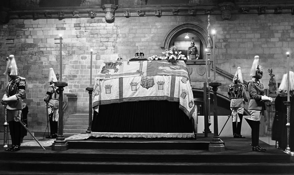 FILE - The remains of King George V lie in state until the royal funeral, with the Household troops standing guard at Westminster Hall in London on Jan. 23, 1936. When Queen Elizabeth II’s grandfather, King George V, died in 1936, life in Britain is unrecognizable to people today. But despite almost a century of change, the images from the queen’s lying in state this week are almost exact copies of those from George V’s time. (AP Photo, File)