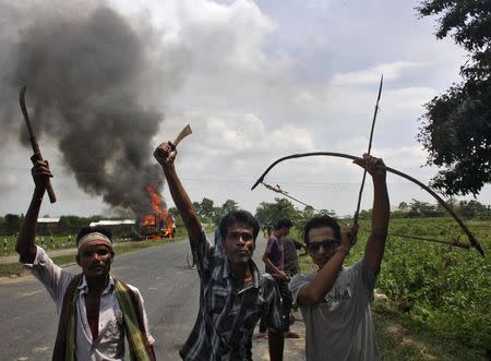 Demonstrators with their weapons shout slogans during a protest at Golaghat district in Assam August 20, 2014. REUTERS/Stringer