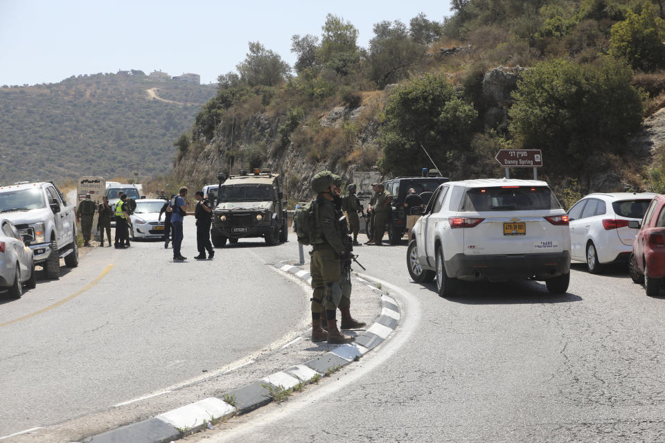 Israeli soldiers secure an area near Dolev settlement in the West Bank, Friday, Aug. 23, 2019, after three Israelis were wounded in an explosion. The Israeli military said it suspects the explosion near Dolev settlement, northwest Jerusalem, to be a Palestinian attack. (AP Photo/Mahmoud Illean)