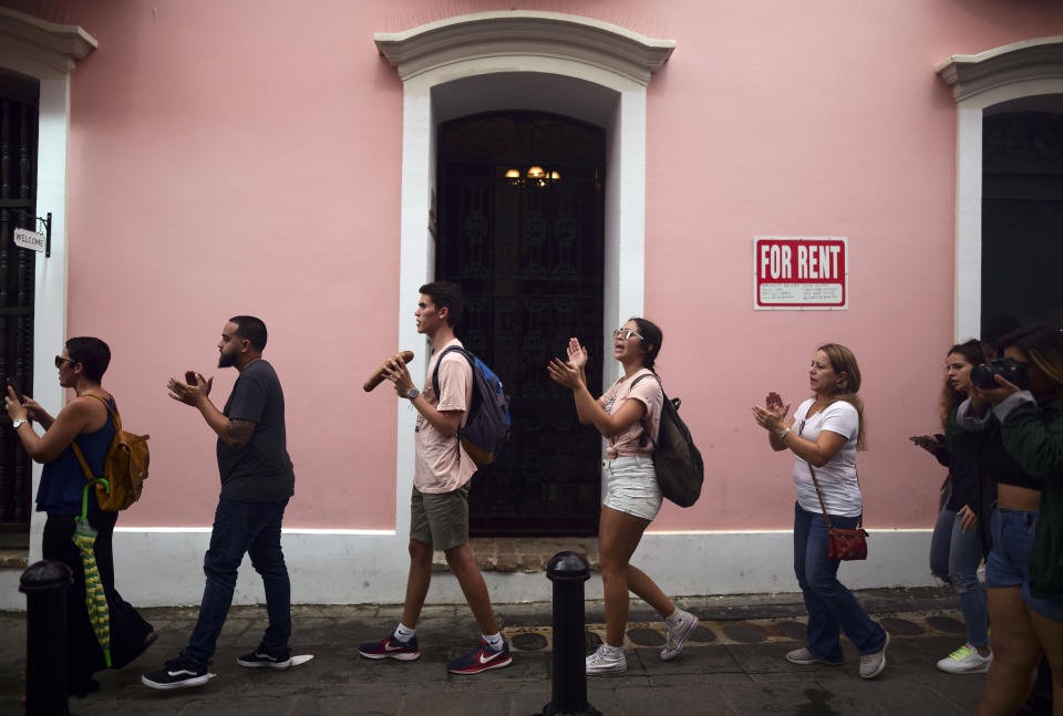 People protest outside the executive mansion known has La Fortaleza in Old San Juan demanding the resignation of Governor Wanda Vázquez after the discovery of an old warehouse filled with emergency supplies in San Juan, Puerto Rico, Monday, Jan. 20, 2020. Anger erupted in Puerto Rico on Saturday after an online blogger posted a live video of the warehouse in the southern coastal city of Ponce filled with water bottles, cots, baby food and other basic supplies that had apparently been sitting there since Hurricane Maria battered the U.S. territory in September 2017. (AP Photo/Carlos Giusti)