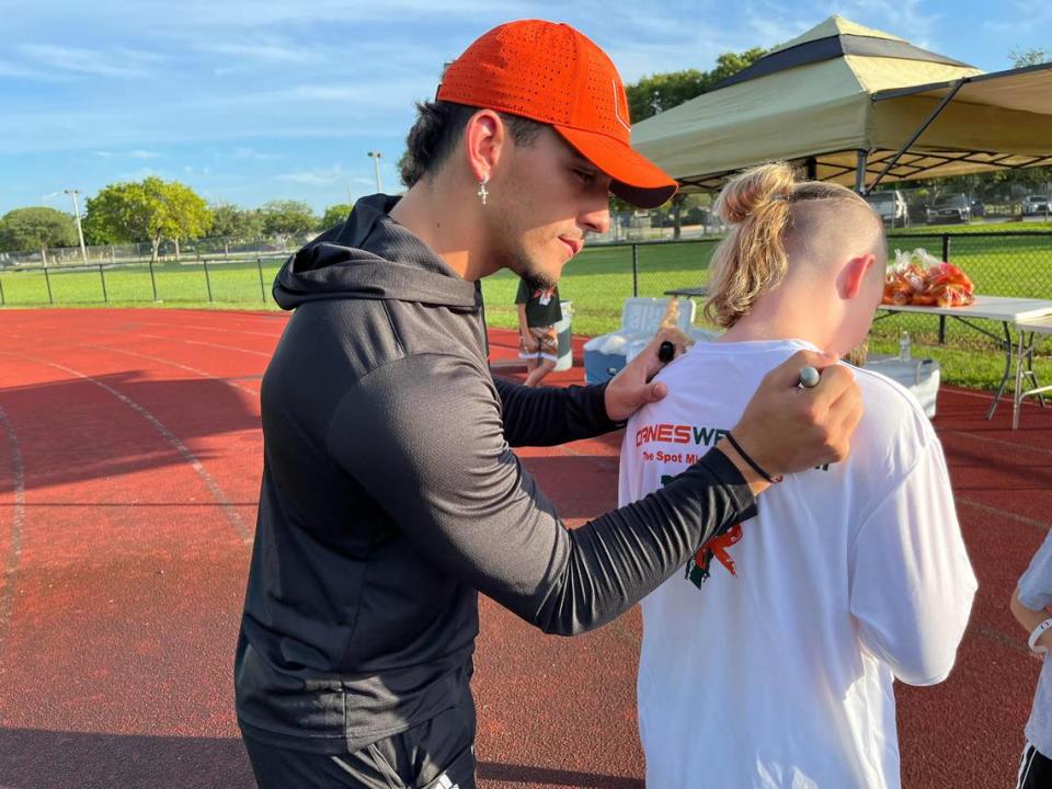 Miami Hurricanes receiver Xavier Restrepo signs the T-shirt of 11-year-old Brody Hameister at Restrepo’s youth camp on Saturday, July 15, at Monarch High in Coconut Creek.