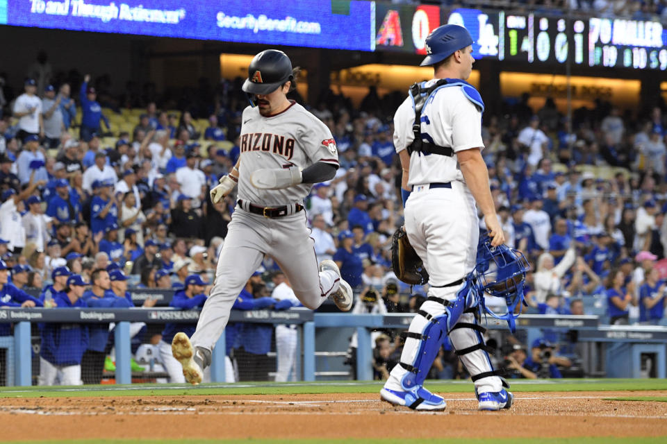 Arizona Diamondbacks' Corbin Carroll (7) scores past Los Angeles Dodgers catcher Will Smith on a sacrifice fly ball by Christian Walker during the first inning in Game 2 of a baseball NL Division Series against the Los Angeles Dodgers, Monday, Oct. 9, 2023, in Los Angeles. (AP Photo/Mark J. Terrill)