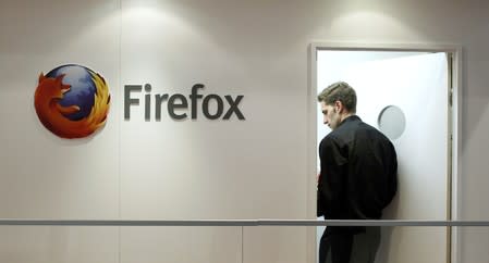 A man is seen next to a Firefox logo at a Mozilla stand during the Mobile World Congress in Barcelona