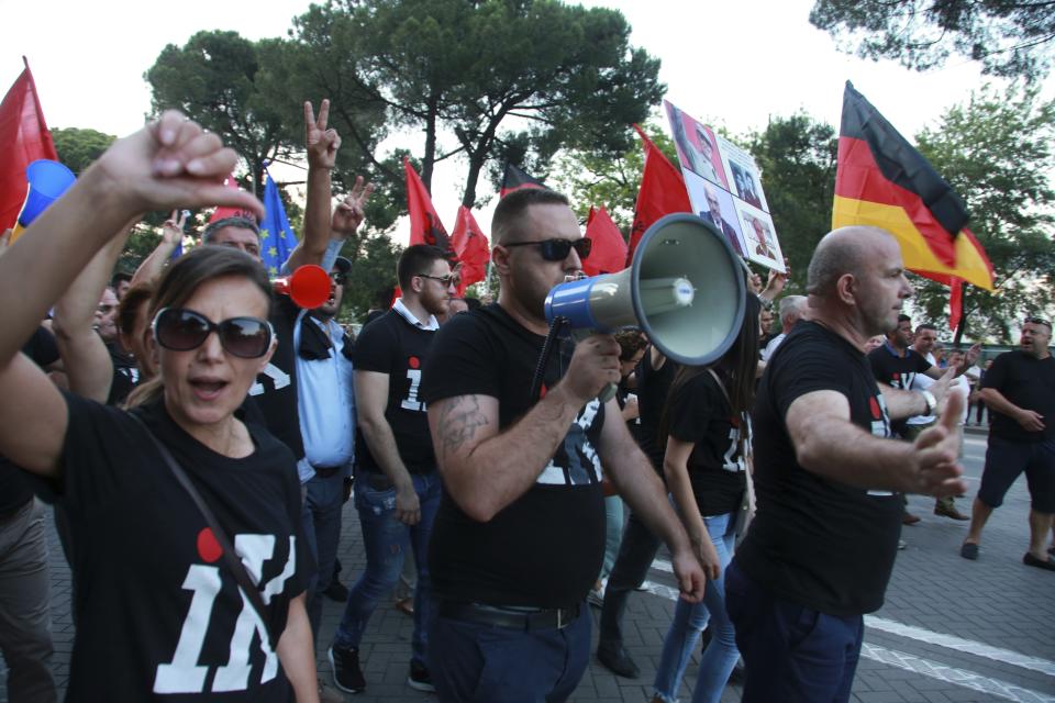 Antigovernment protesters wearing T-shirts with the word "Go", shout slogans during a rally in Tirana, Friday, June 21, 2019. The opposition is boycotting the local elections planned for June 30 and has threatened to disrupt them. (AP Photo/Hektor Pustina)