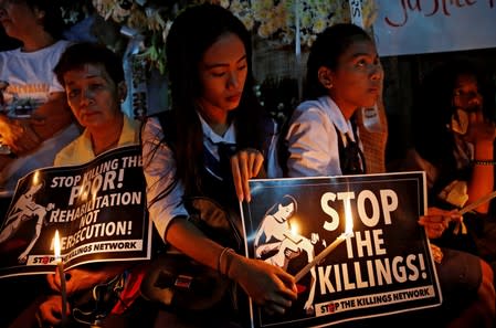 FILE PHOTO: Protesters and residents hold lighted candles and placards at the wake of Kian Loyd delos Santos, a 17-year-old high school student, who was among the people shot dead last week in Manila