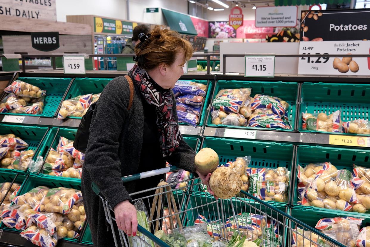 food prices  Shopping for root vegetables in Morrison's supermarket, Britain, United Kingdom. Vegetable fresh shop shopper woman mother retailer retail