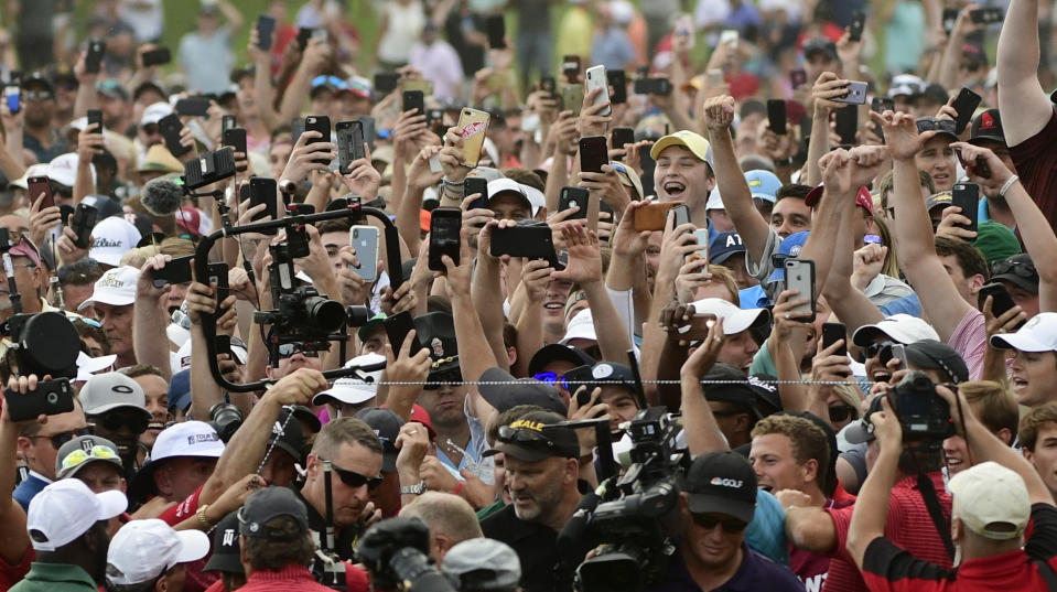 Fans fill the 18th fairway surrounding Tiger Woods and Rory McIlroy as they make their way to the green during the final round of the Tour Championship golf tournament Sunday, Sept. 23, 2018, in Atlanta. (AP Photo/John Amis)