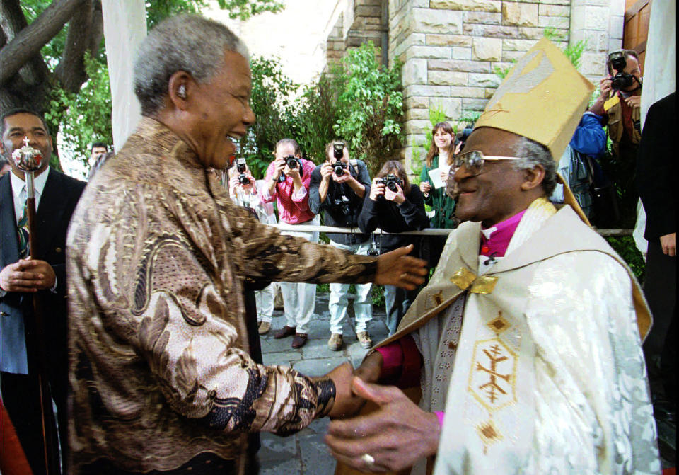 FILE - Retiring Archbishop of Cape Town Desmond Tutu, right, greets President Nelson Mandela at a service in Cape Town, June 23, 1996 held to celebrate the end of Tutu's tenure as leader of the Anglican Church in South Africa. When Tutu died Sunday, Dec. 26, 2021 at age 90, he was remembered as a Nobel laureate, a spiritual compass, a champion of the anti-apartheid struggle who turned to other global causes after Nelson Mandela, another moral heavyweight, became South Africa's first Black president. (AP Photo/Guy Tillim, File)