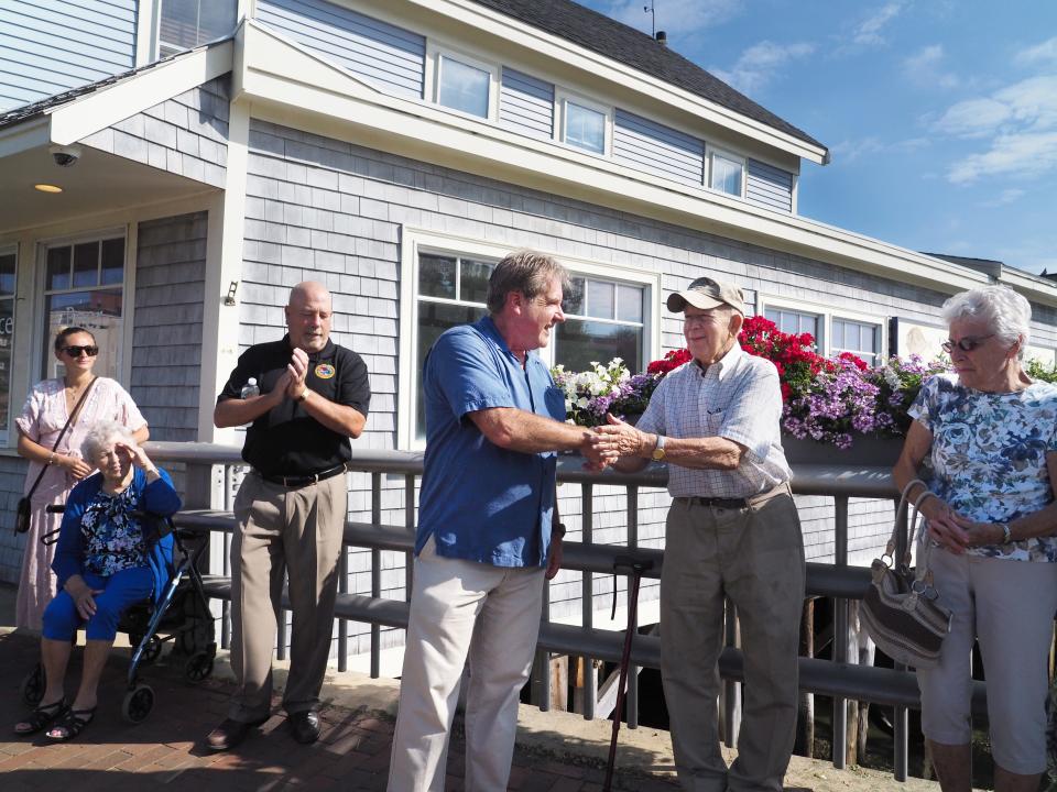 Portsmouth City officials including City Manager John Bohenko, left, and Mayor Jack Blalock congratulate Harold Whitehouse after the bridge on South Street was renamed to the Harold "Whitey" Whitehouse Bridge in 2018.