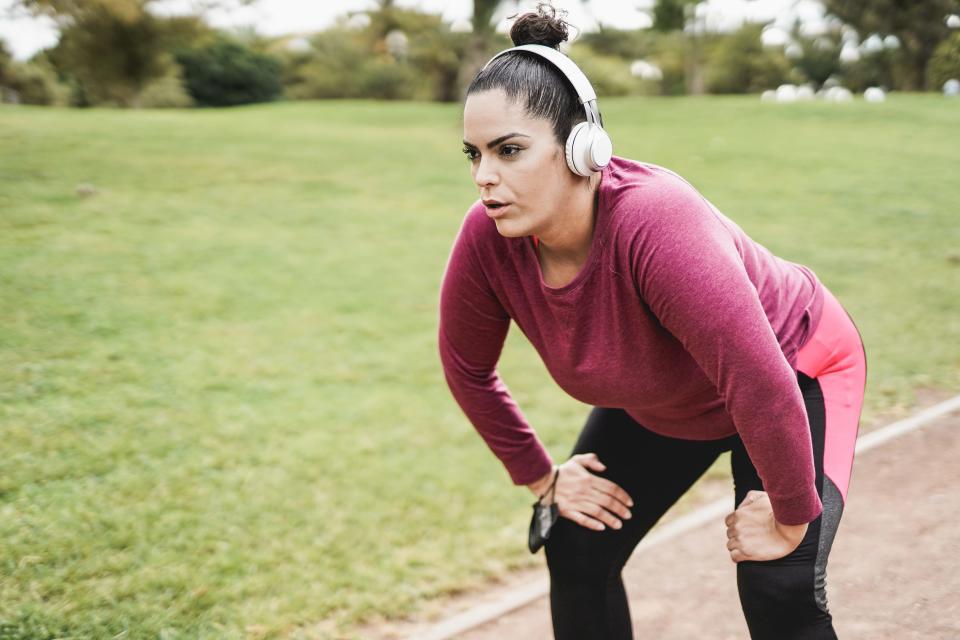 A woman pausing on a run.