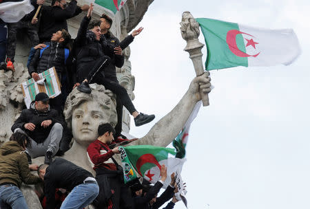 Protestors hold Algerian flags as they attend a demonstration against President Abdelaziz Bouteflika on the Place de la Republique, in Paris, France, March 10, 2019. REUTERS/Philippe Wojazer