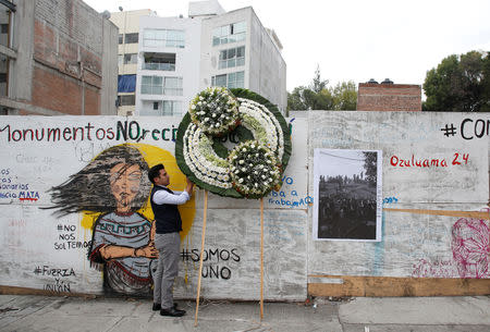 A man places a wreath to honour the victims of a building that collapsed during the September 2017 earthquake in Mexico City, Mexico September 19, 2018. REUTERS/Gustavo Graf