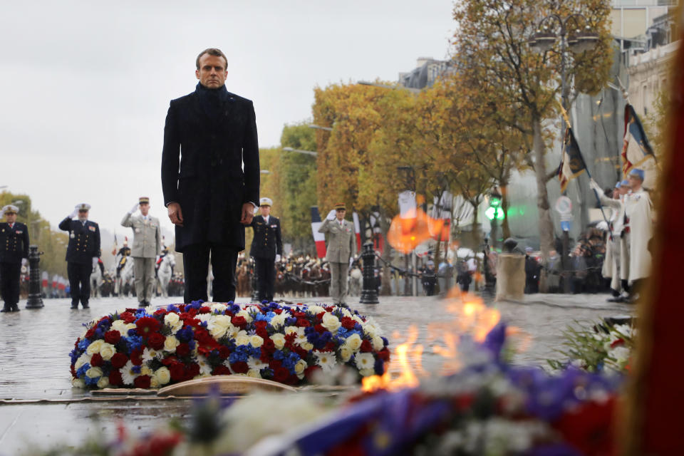 French President Emmanuel Macron stand at the tomb of the unknown soldier under the Arc de Triomphe during commemorations marking the 101st anniversary of the 1918 armistice, ending World War I, in Paris Monday Nov. 11, 2019 . (Ludovic Marin/Pool via AP)