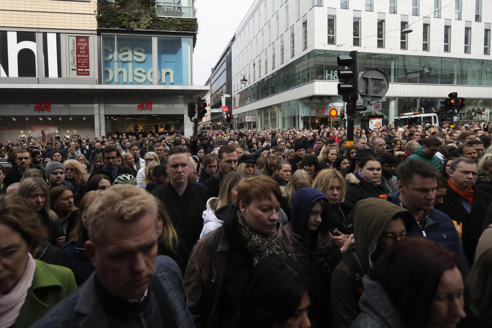 People observe a minute of silence near the department store Ahlens in Stockholm, Sweden, Monday, April 10, 2017, to honor the four killed victims and 15 injured in a fatal truck attack. The attack was allegedly carried out by an asylum-seeker from Uzbekistan who drove the stolen vehicle into a crowd of shoppers on a busy Friday afternoon in downtown Stockholm. (AP Photo/Markus Schreiber)